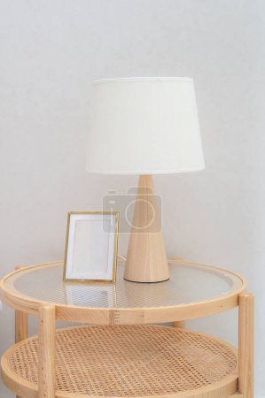 Téléchargez les photos : Design intérieur photo réelle de lampe blanche et cadre maquette vierge sur armoire de chevet en bois. - en image libre de droit
