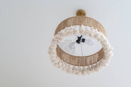 Téléchargez les photos : Lustre en corde tissée, abat-jour en tissu d'osier naturel sous plafond blanc - en image libre de droit