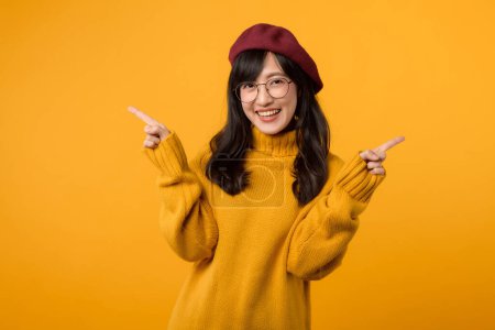 Téléchargez les photos : Jeune femme élégante en béret rouge et pull jaune sur un fond jaune vif, mettant en valeur un choix de mode. - en image libre de droit