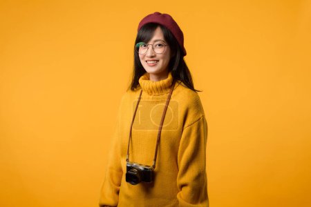 En su elegante estudio, la joven asiática, vestida con un suéter amarillo y una boina roja, toma un retro retrato usando su amada cámara, que recuerda a la nostalgia de los años 20 y 30..