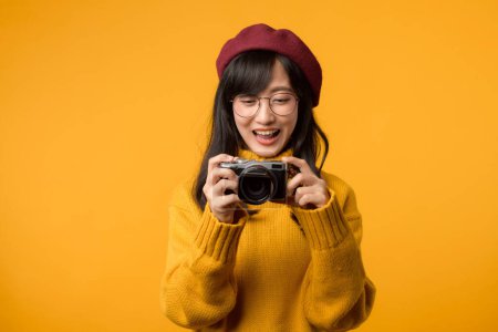 Con su cámara en la mano, la joven asiática, una fotógrafa experta, viaja por el mundo en su suéter amarillo y boina roja, conservando hermosos momentos en el tiempo.
