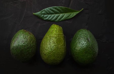 Photo for Three different types of avocados on a black background. Bacon, reed, hass. - Royalty Free Image