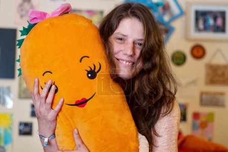 Photo for Portrait of woman with heavy Cuts and scars of self-mutilation in frustration, self-abusing, Borderline personality disorder, hugging a big carrot cuddly toy heart, copy space - Royalty Free Image