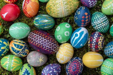 muchos huevos de Pascua coloridos pintados a mano, según la tradición sorbia al aire libre en el musgo, espacio para copiar