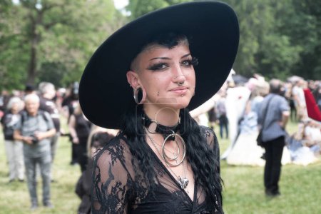 Joven, sonriente, gótica femenina en traje negro en el anual Wave Gotik Treffen (Wave Gothic Meeting) en Leipzig, picnic victoriano, Clara-Zetkin-Park, espacio para copiar,