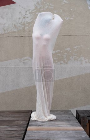 Foto de Sexy mujer desnuda joven en blanco húmedo vestido de algodón transparente como una escultura de arte moderno al aire libre, espacio de copia - Imagen libre de derechos