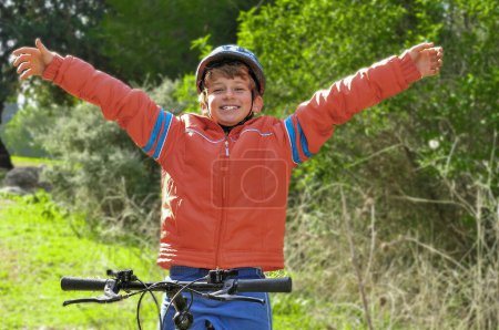 Photo for A boy rejoices after winning a bicycle race at a school competition - Royalty Free Image