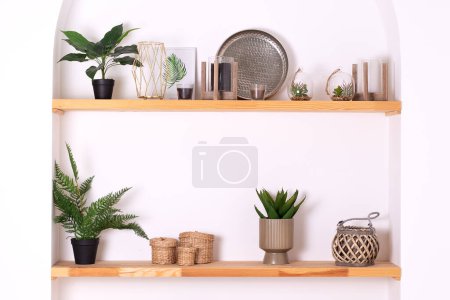 Photo for Modern composition of wabi sabi interior with shelf with stylish home decoration. Boho interior of living room and wooden shelves with elegant decor, vase, green houseplants in pots and candles. - Royalty Free Image