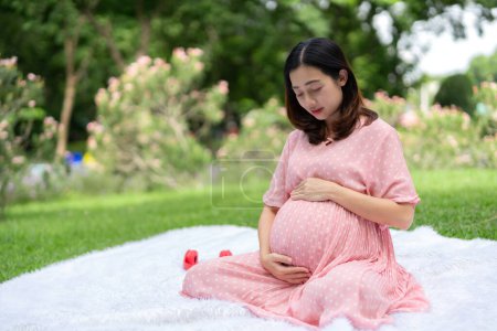 Foto de Retrato de mujer embarazada asiática relajándose y en el parque - Imagen libre de derechos