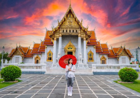 Foto de Retrato de una hermosa mujer joven con traje nacional tailandés Rattanakosin en un templo construido de acuerdo con el arte tailandés en Tailandia - Imagen libre de derechos