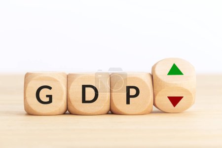 GDP or gross domestic product up or down concept. Text on wooden blocks and turning dice with up and down arrows. Copy space