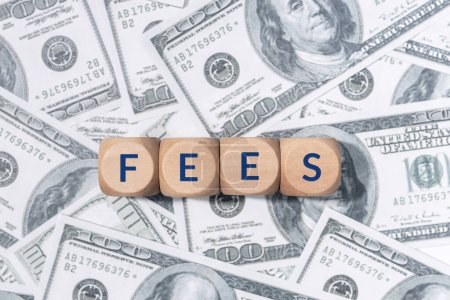 Foto de FEES palabra en bloques de madera y billetes de dólar de fondo - Imagen libre de derechos