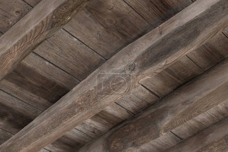 Underside view of an old wooden floor structure of a building damaged by woodworm holes