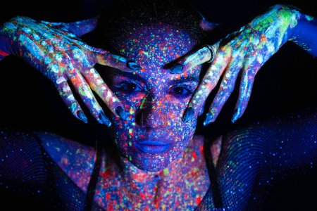 Photo for Fashion model woman in neon light, portrait of a beautiful model with fluorescent makeup, artistic design of disco dancers posing in UV, colorful makeup. Isolated on black background - Royalty Free Image