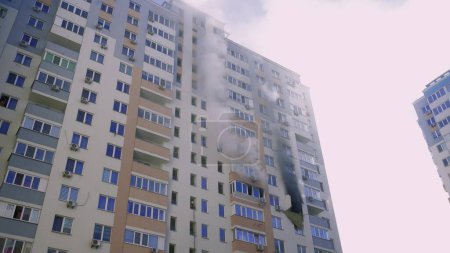 Foto de Kyiv, Ukraine - November 15, 2022: Fire in an apartment building, firefighters fighting the flames, burning house, fire disaster and accident tragedy concept - Imagen libre de derechos