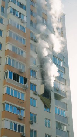 Foto de KYIV, UKRAINE - NOVEMBER 15, 2022: Fire in an apartment building. Blue smoke billows from the windows of the apartment. Extinguishing a fire in an apartment building. vertical video - Imagen libre de derechos