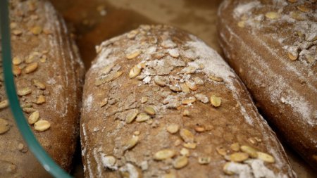 Téléchargez les photos : Des pains de seigle se trouvent sur l'étagère de la boulangerie en bois. Gros plan. Shopping à l'épicerie. Concept de vente d'aliments - en image libre de droit