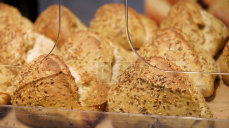 Téléchargez les photos : Pâtisserie au pain entier sain et cuit au four avec sésame et graines de lin. Shopping à l'épicerie. Concept de vente d'aliments - en image libre de droit