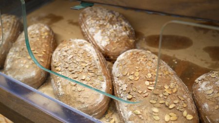 Téléchargez les photos : Du pain frais sur les étagères de la boulangerie du supermarché. Shopping à l'épicerie. Concept de vente d'aliments - en image libre de droit