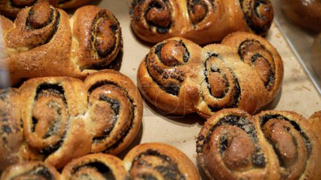 Téléchargez les photos : Rangées de rouleaux de pain fraîchement cuits chauds exposés dans le stand de boulangerie à l'épicerie locale - en image libre de droit