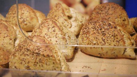 Téléchargez les photos : Pâtisserie au pain entier sain et cuit au four avec sésame et graines de lin. Shopping à l'épicerie. Concept de vente d'aliments - en image libre de droit