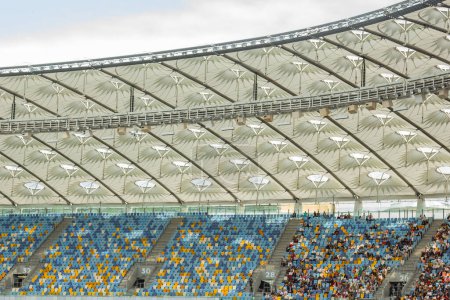 Téléchargez les photos : Stade de football vue de l'intérieur. terrain de football, stands vides, une foule de fans, un toit contre le ciel
. - en image libre de droit