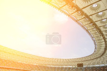 Photo for Soccer stadium inside view. football field, empty stands, a crowd of fans, a roof against the sky. - Royalty Free Image