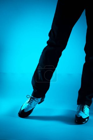 Téléchargez les photos : Danseuse masculine dansant en jazz latino chaussures de bal avec fond de couleur unie - en image libre de droit