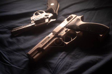 Téléchargez les photos : Pistolet sur drap de lit nature morte crime thriller livre couverture conception. - en image libre de droit
