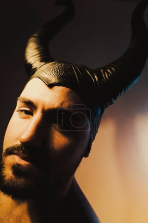 Téléchargez les photos : Homme avec des cornes sur la tête studio tourné portrait withe diable mauvais regard. - en image libre de droit