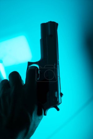 Téléchargez les photos : Main de l'homme tenant 9mm pistolet dans le crime thriller livre couverture conception photo. - en image libre de droit