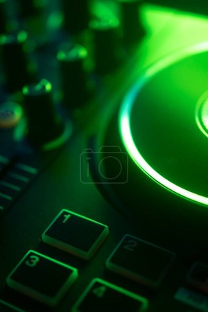 Téléchargez les photos : DJ table tournante de mélange de bureau dans les lumières colorées de fête de disco de mariage. - en image libre de droit