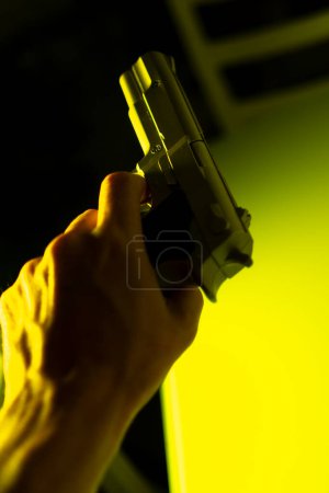 Téléchargez les photos : Main de l'homme tenant 9mm pistolet dans le crime thriller livre couverture conception photo. - en image libre de droit