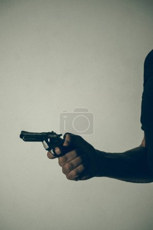 Téléchargez les photos : Gunman tueur tenant pistolet photo artistique livre couverture design avec des couleurs et de l'éclairage. - en image libre de droit
