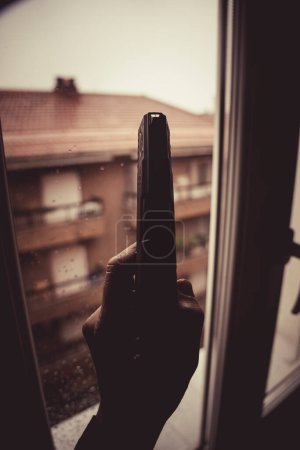 Téléchargez les photos : Gunman tenant le pistolet dans la conception dramatique de couverture de livre photo fenêtre.. - en image libre de droit