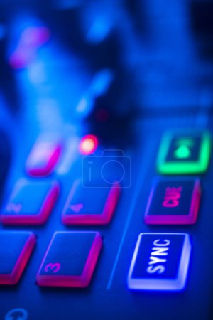 Téléchargez les photos : DJ table tournante de mélange de bureau dans les lumières colorées de fête de disco de mariage. - en image libre de droit