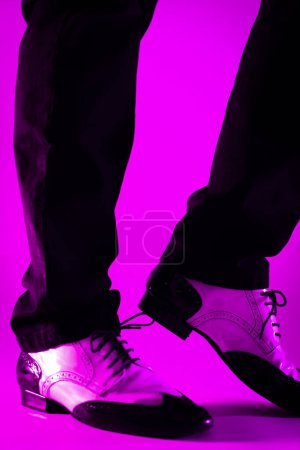 Téléchargez les photos : Danseuse masculine dansant en jazz latino chaussures de bal avec fond de couleur unie - en image libre de droit