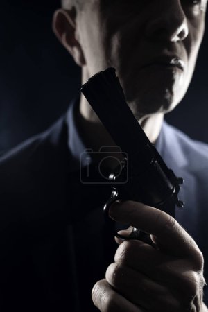 Foto de Asesino espía Assasin con pistola de pistola en traje elegante y camisa libro thriller cubierta digna. - Imagen libre de derechos