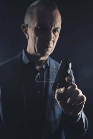 Foto de Asesino espía Assasin con pistola de pistola en traje elegante y camisa libro thriller cubierta digna. - Imagen libre de derechos
