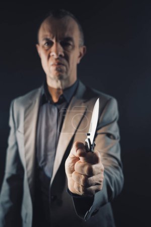 Foto de Asesino asesino asesino sosteniendo cuchillo arma de hoja en oscuro espeluznante foto libro cubierta diseño. - Imagen libre de derechos