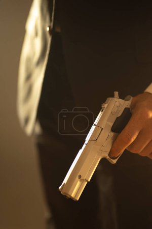 Téléchargez les photos : Homme détective espion tueur tenant pistolet dans le roman dramatique couverture de livre conception couleur photo. - en image libre de droit