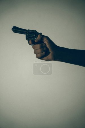 Téléchargez les photos : Gunman tueur tenant pistolet photo artistique livre couverture design avec des couleurs et de l'éclairage. - en image libre de droit