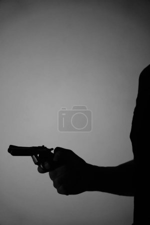 Téléchargez les photos : Homme espion détective tenant pistolet pistolet livre couverture conception artistique photo noir et blanc éclairage. - en image libre de droit