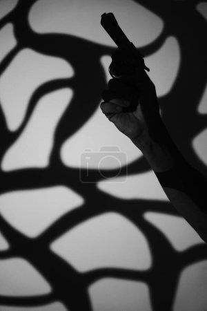 Téléchargez les photos : Homme espion détective tenant pistolet pistolet livre couverture conception artistique photo noir et blanc éclairage. - en image libre de droit