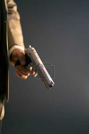 Téléchargez les photos : Homme détective espion tueur tenant pistolet dans le roman dramatique couverture de livre conception couleur photo. - en image libre de droit