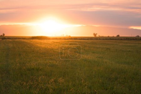 Foto de Puesta de sol sobre una granja y campos agrícolas - Imagen libre de derechos