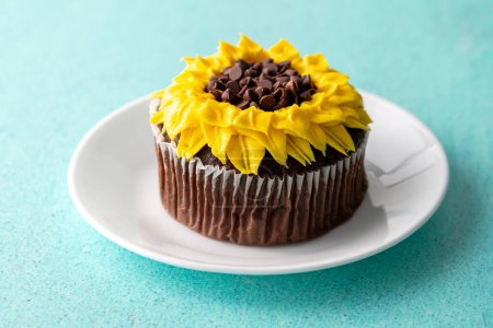 Photo for Beautiful sunflower decorated chocolate cupcake on aqua pastel background - Royalty Free Image