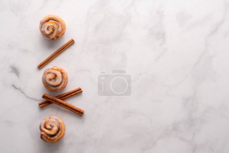 Photo for Homemade baked cinnamon rolls with marble slab background and space for text. - Royalty Free Image