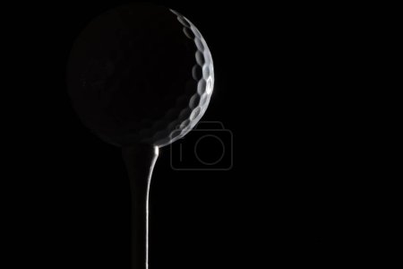 Balle de golf sur tee souligné contraste grande épopée