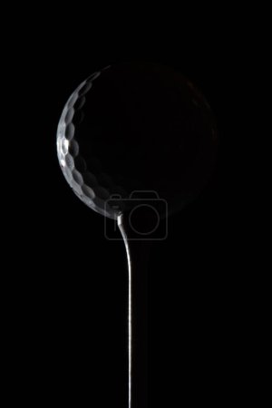 Balle de golf sur tee souligné contraste grande épopée